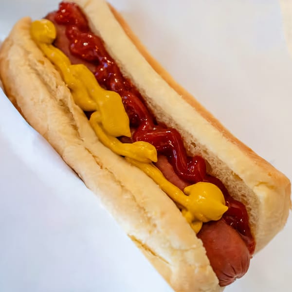 El Capitan's hot dog with ketchup and mustard on a white background.