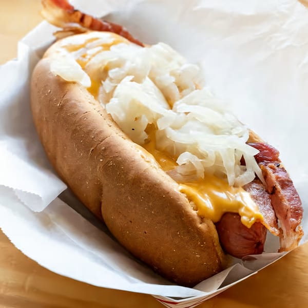 El Capitan's hot dog with bacon, melted cheese, and sauerkraut in a paper tray.
