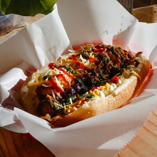 El Capitan's hot dog with various toppings, including sauces, cheese, and green relish.
